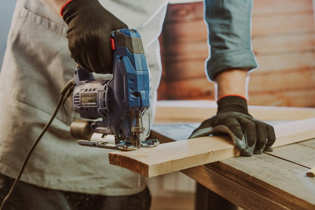 Carpenter using jigsaw for cutting wood